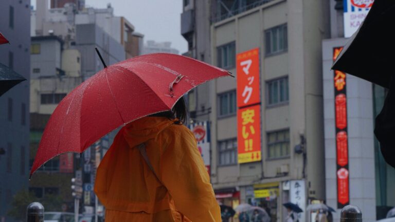 Crowded Tokyo street with international tourists, bright signage, and busy pedestrian crossings during peak travel season