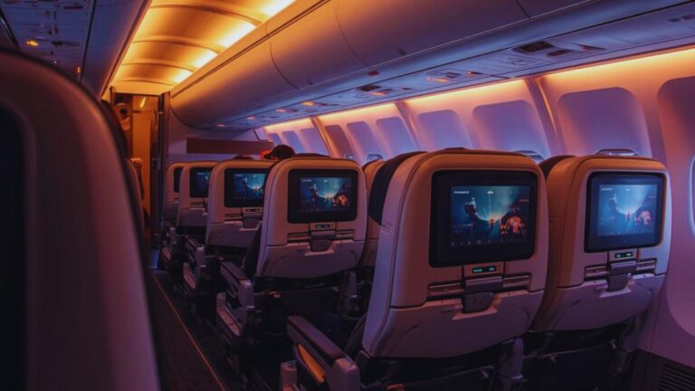 Premium economy airplane cabin with wider seats, extra legroom, and modern lighting