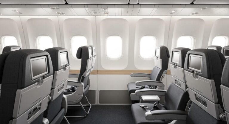 Empty premium economy cabin on a modern long-haul aircraft, showcasing comfortable seating and spacious legroom.