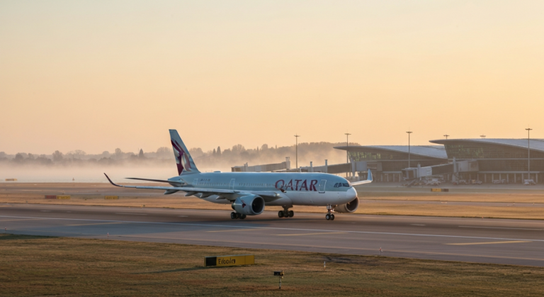 Qatar Airways aircraft parked on the runway at Venice Marco Polo Airport at sunrise
