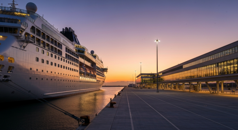 Modern cruise ship docked at a newly developed, elegantly lit Port of Galveston terminal.